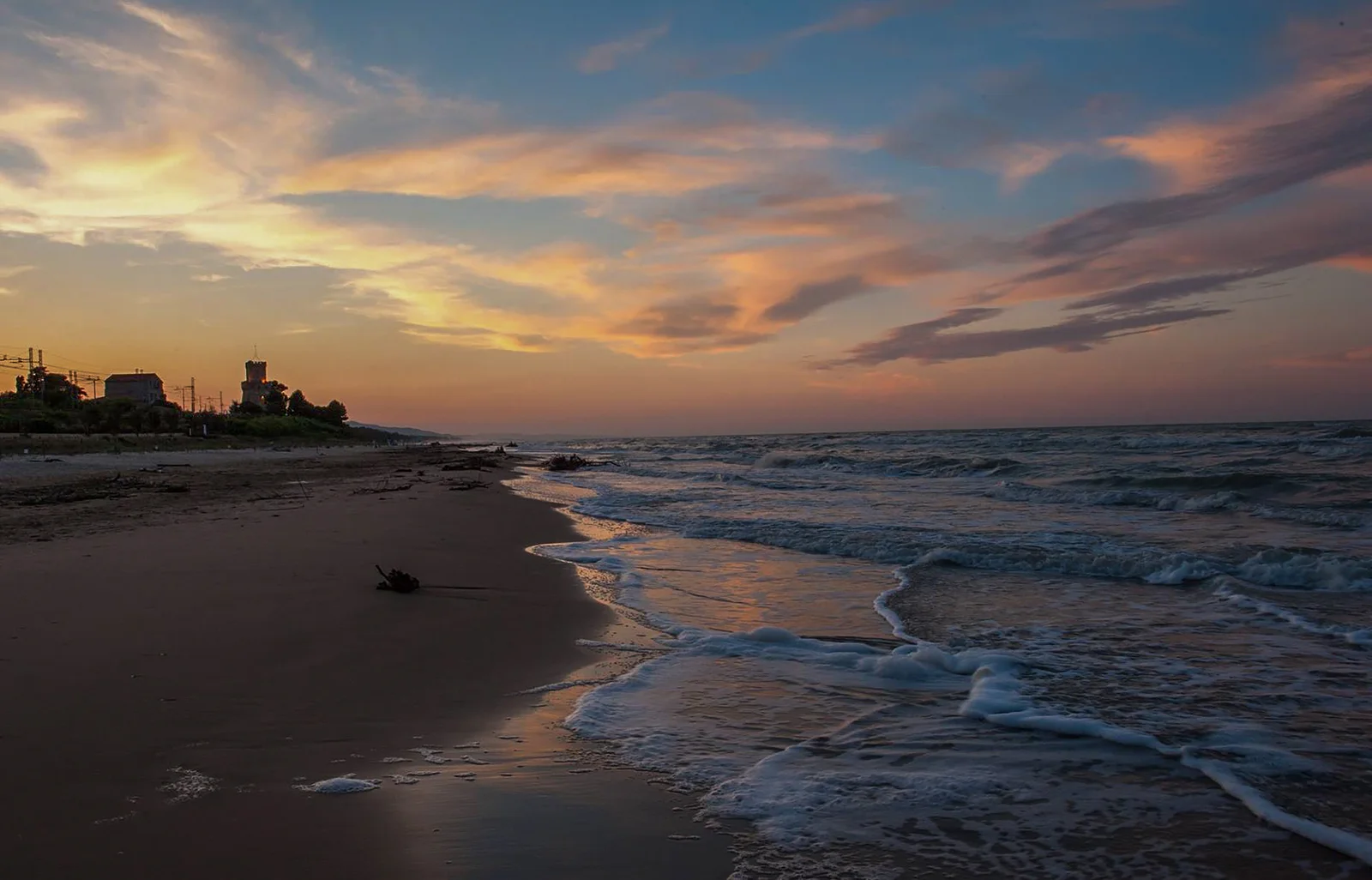 Waves washing onto the beach at Torre del Cerrano in Pineto beneath a warm evening sky